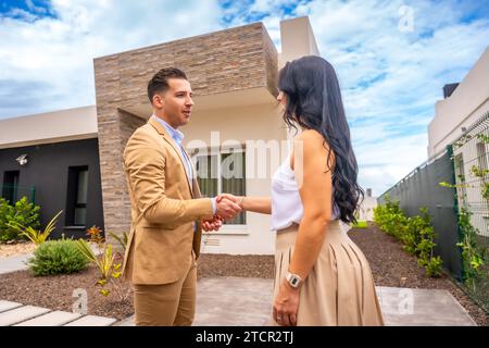 Femme serrant la main à un agent immobilier achetant une maison Banque D'Images