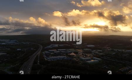 Une vue grand angle d'un coucher de soleil spectaculaire sur une grande zone métropolitaine, avec le système d'autoroute visible au premier plan Banque D'Images