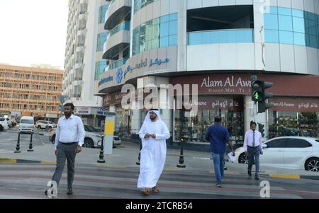 Un homme émirati traversant la rue à Sharjah, Émirats arabes Unis. Banque D'Images