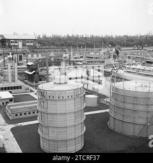 Madurodam, la Haye, pays-Bas photographié en 1955 – cette vue montre la partie industrielle du parc avec son port, ses navires et ses réservoirs de gaz (gazomètres) au premier plan. Madurodam est un parc à thème miniature, un « village » modèle et une attraction touristique dans le quartier de Scheveningen à la Haye. Il abrite une gamme de répliques à l'échelle 1:25 de célèbres monuments hollandais et le style de vie, les villes historiques, l'industrie et les développements. Le parc a été ouvert en 1952 et des dizaines de millions de visiteurs ont visité l'attraction avec les bénéfices du parc allant à diverses associations caritatives aux pays-Bas. Banque D'Images