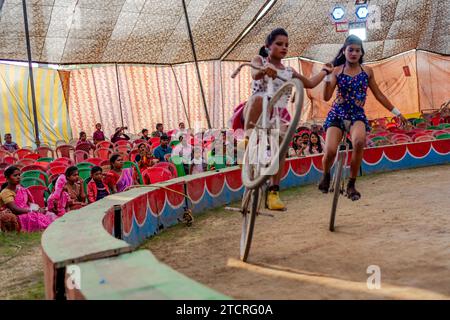 Kolkata, Inde. 14 décembre 2023. Les gens dans le public apprécient une représentation de deux femmes sur des cycles pendant le spectacle de cirque. L'hiver et l'enfance signifiaient une époque où il y avait une attraction et un amour distincts pour le cirque. Mais maintenant, les temps ont changé de sorte que la demande a également diminué, surtout après que le spectacle de tout type d'animaux dans le cirque a cessé, les propriétaires des équipes de cirque sont plus contrariés. Maintenant, le jeu est montré seulement avec des jokers ou des gens. Et en conséquence, le revenu a diminué. Maintenant, même les plus petits ont perdu tout intérêt pour le cirque. Crédit : SOPA Images Limited/Alamy Live News Banque D'Images