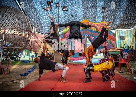 Kolkata, Inde. 14 décembre 2023. Les artistes de cirque du Manipur pratiquent leurs cascades à l'intérieur d'une tente de cirque avant la représentation finale. L'hiver et l'enfance signifiaient une époque où il y avait une attraction et un amour distincts pour le cirque. Mais maintenant, les temps ont changé de sorte que la demande a également diminué, surtout après que le spectacle de tout type d'animaux dans le cirque a cessé, les propriétaires des équipes de cirque sont plus contrariés. Maintenant, le jeu est montré seulement avec des jokers ou des gens. Et en conséquence, le revenu a diminué. Maintenant, même les plus petits ont perdu tout intérêt pour le cirque. Crédit : SOPA Images Limi Banque D'Images