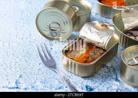 Sardines en conserve en boîte de métal sur fond bleu Banque D'Images