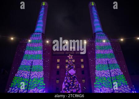 Londres, Royaume-Uni. 13 décembre 2023. L’artiste britannique David Hockney projette deux arbres de Noël animés sur les cheminées de la Battersea Power Station à Londres. Capitale britannique, Londres est très célèbre dans le monde entier pour ses lumières de Noël, ses marchés et ses bâtiments emblématiques. Crédit : SOPA Images Limited/Alamy Live News Banque D'Images