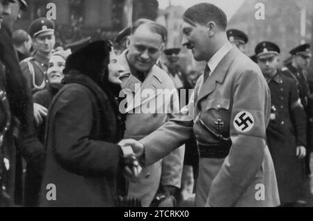 Adolf Hitler est présenté le jour de la réunification de la Sarre, un événement important dans l'histoire de l'Allemagne nazie. Cette occasion marque le retour de la Sarre en Allemagne à la suite d'un plébiscite de la ligue des nations en 1935. La présence d'Hitler lors de cet événement charnière est emblématique des ambitions territoriales et nationalistes du régime. L'image sert probablement à dépeindre Hitler comme un restaurateur des terres allemandes et de la fierté nationale, s'alignant sur le récit plus large de la récupération des territoires séparés après la première Guerre mondiale Banque D'Images