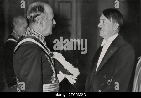 Adolf Hitler, chancelier du Reich, est montré engagé dans une conversation avec l'ambassadeur de France, André François-Poncet, lors d'une réception du nouvel an. Cette interaction représente un moment de diplomatie de haut niveau entre l’Allemagne nazie et la France. Banque D'Images