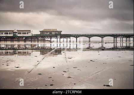 St Annes jetée reflétée dans la plage humide en hiver Banque D'Images
