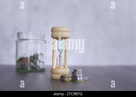 Image en gros plan de sablier et de pièces de monnaie avec espace de copie pour le texte. Concept financier. Banque D'Images