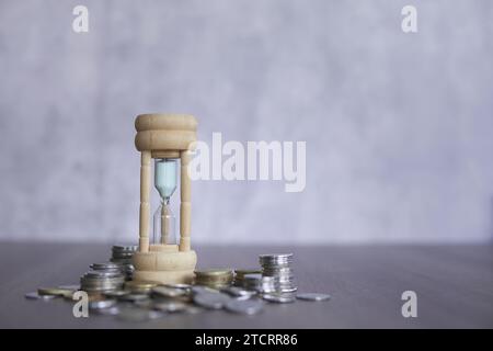 Image en gros plan de sablier et de pièces de monnaie avec espace de copie pour le texte. Concept financier. Banque D'Images