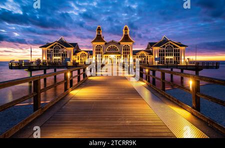 Célèbre Sellin Seebruecke (Sellin Pier) dans le beau crépuscule du soir au crépuscule en été, Ostseebad Sellin station touristique, mer Baltique, Allemagne. Banque D'Images