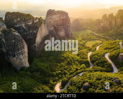 Meteora, Grèce. Formations rocheuses de grès, monastères Rousanou et Nikolaos au coucher du soleil. Arrière-plan de destination de voyage. Vue panoramique. Banque D'Images