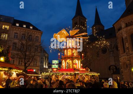 Bonn, Allemagne - 6 décembre 2023 : une pyramide traditionnelle du marché de Noël la nuit avec des lumières festives et des décorations avec deux lumières brillantes, géantes Banque D'Images