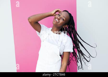Portrait d'une jeune femme positive en vêtements blancs décontractés regardant la caméra Banque D'Images