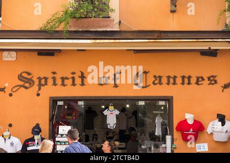 Boutique de T-shirts touristiques « Spirit of Cannes » à Cannes, France. Détaillant vendeur vendant des tee-shirts et d'autres articles vestimentaires sur une rue / route achalandée. (135) Banque D'Images