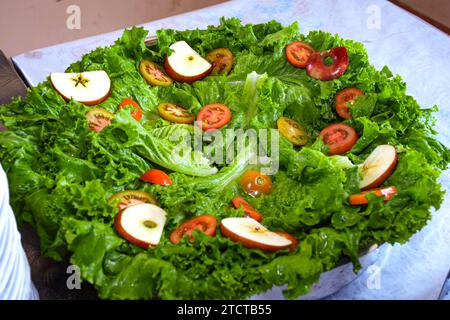 Salade avec radis, tomates et pomme sur une assiette en buffet. Délicieuses salades sur la table du buffet au restaurant Banque D'Images