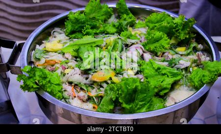 Salade avec radis, tomates et pomme sur une assiette en buffet. Délicieuses salades sur la table du buffet au restaurant Banque D'Images