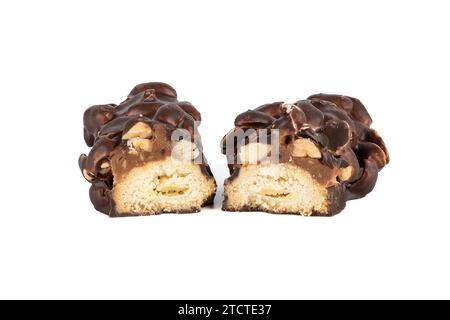 Deux moitiés d'un gâteau sucré avec des noix recouvertes de chocolat sur un fond blanc. Espace de copie. Banque D'Images