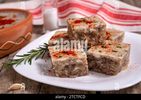 Pihtije - plat traditionnel serbe. Cubes d'aspic avec de la viande de porc sur une assiette. Mise au point sélective. Banque D'Images