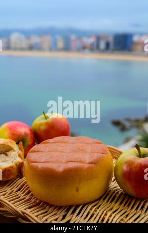 Fromage de vache fumé espagnol de Pria, Asturies, servi en plein air avec vue sur la plage de San Lorenzo et la promenade de Gijon Banque D'Images