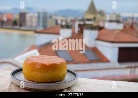 Fromage de vache fumé espagnol de Pria, Asturies, servi en plein air avec vue sur la plage de San Lorenzo et la promenade de Gijon Banque D'Images