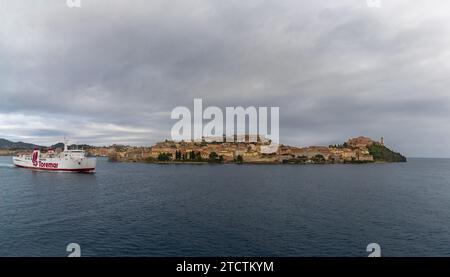 Portoferraio, Italie - 12 novembre 2023 : ferry de Toremar quittant l'île d'Elbe avec Portoferraio vieille ville et port en arrière-plan Banque D'Images