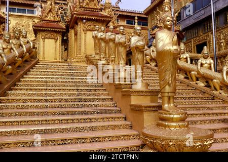 Mongkol Serei Kien Khleang Pagode. Escalier décoré de statues bouddhistes dorées. Phnom Penh ; Cambodge. Banque D'Images