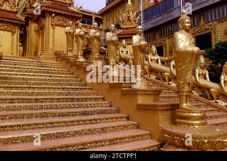 Mongkol Serei Kien Khleang Pagode. Escalier décoré de statues bouddhistes dorées. Phnom Penh ; Cambodge. Banque D'Images