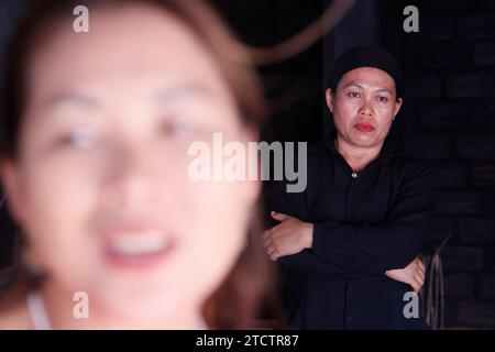 Portrait rapproché d'une femme triste avec une jeune femme souriante floue au premier plan. Banque D'Images