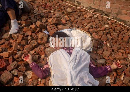 Dhaka, Bangladesh. 14 décembre 2023. Une artiste de théâtre se produit comme une intellectuelle martyrisée alors qu'elle rend hommage. Les Bangladeshis ont rendu hommage aux dizaines d'intellectuels tués pendant la guerre, qui a conduit au succès de l'indépendance du pays d'Asie du Sud vis-à-vis du Pakistan. Les intellectuels ont été systématiquement tués à travers l'ancien Pakistan oriental par l'armée pakistanaise et leurs collaborateurs pour mutiler la nation émergente de son peuple talentueux et intellectuel. (Photo de Sazzad Hossain/SOPA Images/Sipa USA) crédit : SIPA USA/Alamy Live News Banque D'Images