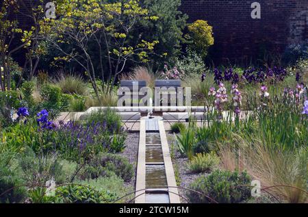 Sièges et fontaine du canal d'eau d'un étang dans le Victorian Weston Walled Paradise Garden à RHS Garden Bridgewater, Worsley, Manchester, Royaume-Uni. Banque D'Images