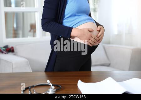 Une femme enceinte se tient devant le bureau pour recevoir un traitement à l'hôpital. Banque D'Images