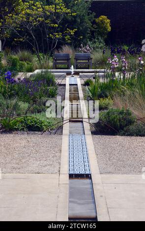 Sièges et fontaine du canal d'eau d'un étang dans le Victorian Weston Walled Paradise Garden à RHS Garden Bridgewater, Worsley, Manchester, Royaume-Uni. Banque D'Images