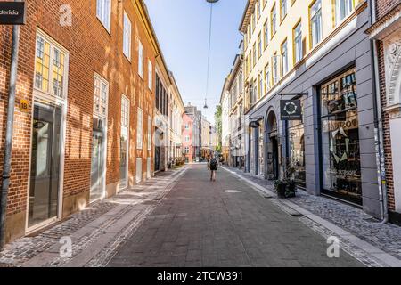 Une touriste féminine avec un sac à dos marche le long de la rue d'une grande ville. Copenhague, Danemark. Banque D'Images