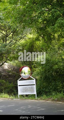 Miroir convexe du trafic extérieur dans les virages en épingle à cheveux et la route ascendante en route vers le sommet de la colline kodaikanal. Installé pour améliorer la sécurité. Banque D'Images