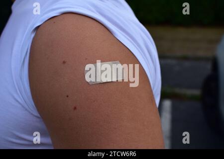 Bandelette beige sur l'épaule après vaccination contre le Covid-19 Banque D'Images