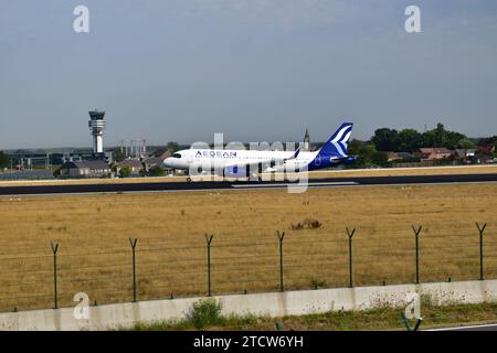 Aegean Airlines A320 atterrit sur la piste 25L avec de la fumée blanche provenant des pneus des trains d'atterrissage à l'aéroport international de Bruxelles Banque D'Images