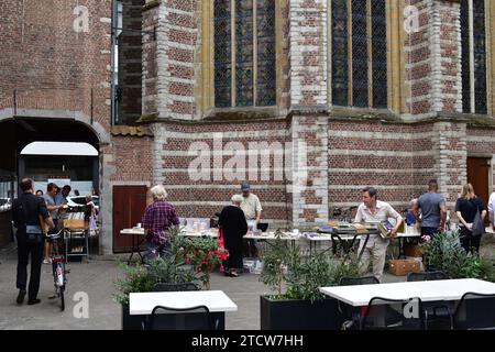 Les citoyens locaux parcourent des livres à la foire du livre d’occasion sur la place Saint Nicolas dans le centre-ville d’Anvers Banque D'Images