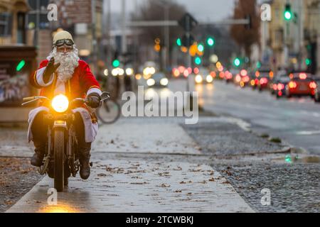 Cottbus, Allemagne. 14 décembre 2023. Un homme habillé comme le Père Noël conduit sa moto vintage sur une route. Crédit : Frank Hammerschmidt/dpa/Alamy Live News Banque D'Images