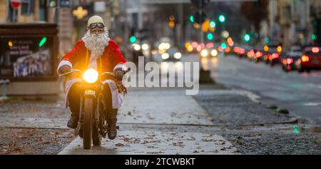 Cottbus, Allemagne. 14 décembre 2023. Un homme habillé comme le Père Noël conduit sa moto vintage sur une route. Crédit : Frank Hammerschmidt/dpa/Alamy Live News Banque D'Images