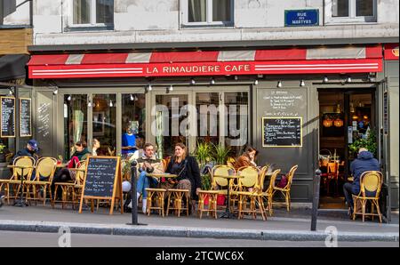 Les gens assis dehors sirotant un verre au café la Rimaudière sur la rue des Martyrs, Paris, France Banque D'Images