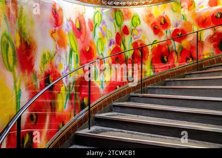 Une peinture colorée de coquelicots sur l'escalier de la station de métro Abbesses dans le 18ème arrondissement, Paris, France Banque D'Images