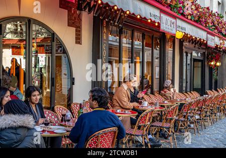 Les gens assis dehors sirotant un verre à la Bohème Montmartre, un restaurant français à Montmartre dans le 18e arrondissement de Paris, France Banque D'Images