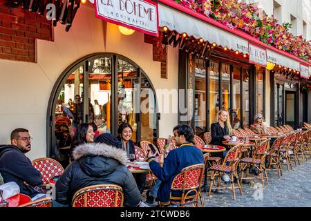 Les gens assis dehors sirotant un verre à la Bohème Montmartre, un restaurant français à Montmartre dans le 18e arrondissement de Paris, France Banque D'Images