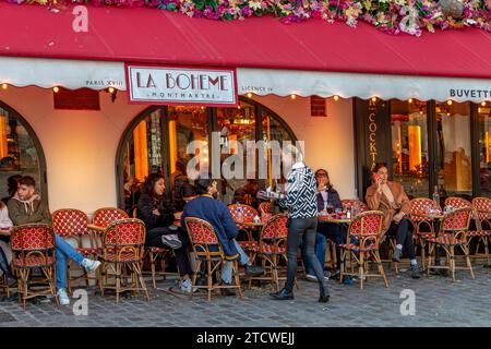 Une serveuse servant une table à la Bohème Montmartre , un restaurant français à Montmartre dans le 18e arrondissement de Paris, France Banque D'Images