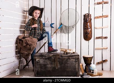 mignonne petite fille dans le chapeau de cow-boy portant sac à dos et filet dans la chambre décorée Banque D'Images