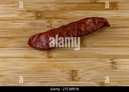 Saucisse de sanglier séchée longue sur une planche à découper en bois, nourriture saine Banque D'Images