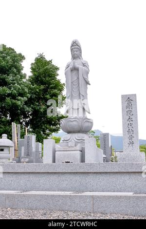 Tombe d'un cimetière japonais avec une sculpture bouddhiste blanche Banque D'Images