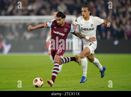 Lucas Paqueta de West Ham United (à gauche) et Kiliann Sildillia de Fribourg se disputent le ballon lors du match de groupe A De l'UEFA Europa League au London Stadium, à Londres. Date de la photo : jeudi 14 décembre 2023. Banque D'Images