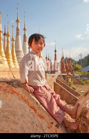 Un jeune portrait birman devant le temple Shwe Inn Thein, village Inn Dein, lac Inle, État Shan, Myanmar. Banque D'Images