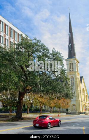 Voiture rouge approchant Citadel Square Baptist Church sur Meeting Street dans la ville historique de Charleston en Caroline du Sud Banque D'Images